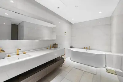 a bathroom with two sinks and a tub and a mirror at Five Palm Residences Sea View in Dubai