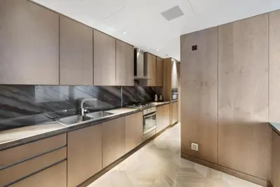 a kitchen with wooden cabinets and stainless steel appliances at Five Palm Residences Sea View in Dubai