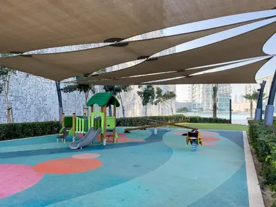 a playground with a slide and an umbrella at Aesthetic 1Br Chrystal Lagoon in Dubai