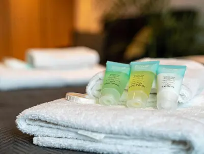 a pile of towels and products on a table at Magnificent Studio, Burj Khalifa view, Marquise Sq in Dubai