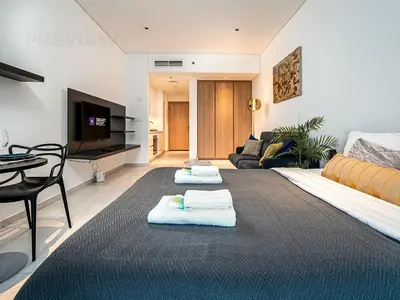 a living room with two towels on a rug at Magnificent Studio, Burj Khalifa view, Marquise Sq in Dubai