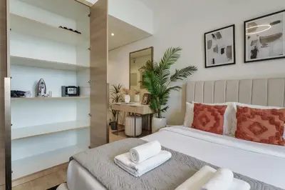 a bedroom with a bed with two towels on it at Stylish Studio with Gym & Pool Access in Dubai