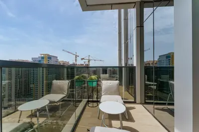 a balcony with chairs and tables on a building at Stylish Studio with Gym & Pool Access in Dubai