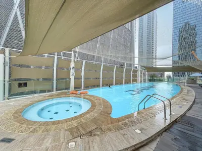 a large swimming pool in a building at Sky-High 1BR with Breathtaking Burj Khalifa View in Dubai