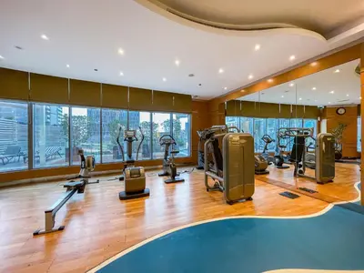 a gym with treadmills and ellipticals in a building at Sky-High 1BR with Breathtaking Burj Khalifa View in Dubai