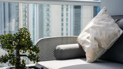 a pillow sitting on a chair in front of a window at Sky-High 1BR with Breathtaking Burj Khalifa View in Dubai