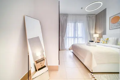 a bedroom with a large bed and a mirror at Upscale 1-Bedroom Apt with Iconic Burj Khalifa View in Dubai
