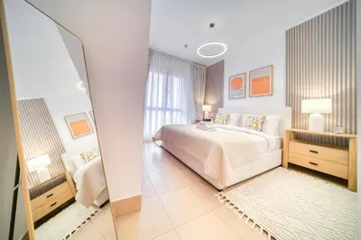 a bedroom with a large white bed and a window at Upscale 1-Bedroom Apt with Iconic Burj Khalifa View in Dubai
