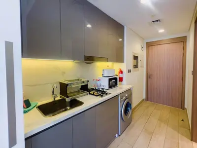 a kitchen with a sink and a washing machine at Chic Studio with Balcony, Netflix and Chill Pet-free in Dubai