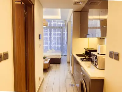 a small kitchen with a bed in a room at Chic Studio with Balcony, Netflix and Chill Pet-free in Dubai