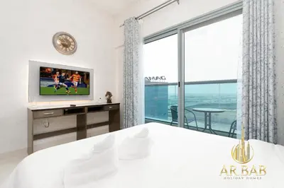 a bedroom with a bed and a tv and a window at Elite Residence - Premium Studio - Best Horse Course View in Dubai