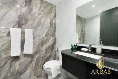 a bathroom with a sink and a toilet and a mirror at Elite Residence - Premium Studio - Best Horse Course View in Dubai
