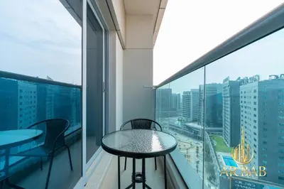 a balcony with a table and chairs and a view of the city at Elite Residence - Premium Studio - Best Horse Course View in Dubai