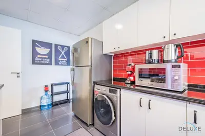 a kitchen with a refrigerator and a microwave at Charming 3BR Townhouse with Study Room in Damac Hills 2 Centaury, Dubailand By Deluxe Holiday Homes in Dubai