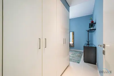 a room with white cabinets and a blue wall at Charming 3BR Townhouse with Study Room in Damac Hills 2 Centaury, Dubailand By Deluxe Holiday Homes in Dubai