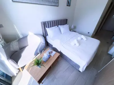 an overhead view of a bedroom with two beds and a couch at Netflix and Wi-Fi Studio Pool, Gym & City Views in Dubai