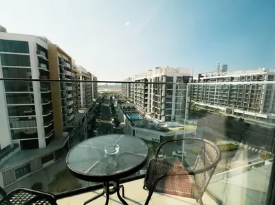 a balcony with a table and chairs and buildings at Netflix and Wi-Fi Studio Pool, Gym & City Views in Dubai