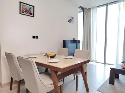 a dining room with a wooden table and chairs at Fast Wi-fi Netflix Cozy 1BR Flat Near Downtown Dubai in Dubai