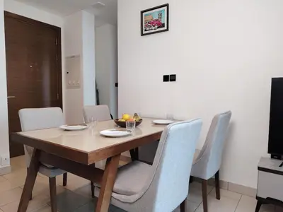 a wooden table with chairs and a bowl of fruit on it at Fast Wi-fi Netflix Cozy 1BR Flat Near Downtown Dubai in Dubai