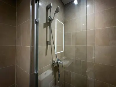 a shower in a bathroom with a glass door at Fast Wi-fi Netflix Cozy 1BR Flat Near Downtown Dubai in Dubai