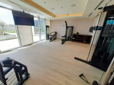a gym with two treadmills and a simulator at Pet free 1BR with Balcony Pool Gym Near Downtown in Dubai