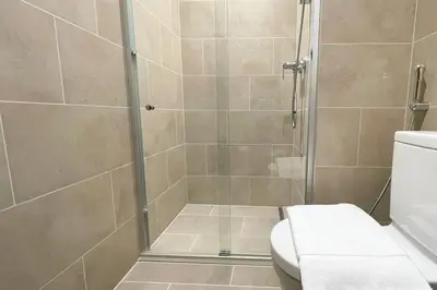 a bathroom with a shower with a toilet at Pet free 1BR with Balcony Pool Gym Near Downtown in Dubai