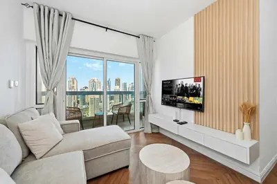 a living room with a couch and a flat screen tv at Stunning 2 Bed Great Metro access in Dubai