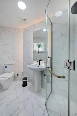 a white bathroom with a sink and a mirror at Stunning 2 Bed Great Metro access in Dubai