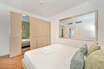 a bedroom with a white bed and a large mirror at Stunning 2 Bed Great Metro access in Dubai