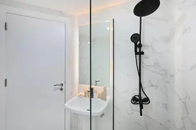 a bathroom with a shower with a sink and a mirror at Stunning 2 Bed Great Metro access in Dubai