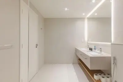 a white bathroom with a sink and a mirror at LA VIE JBR, Sea & Palm View Apartment in Dubai