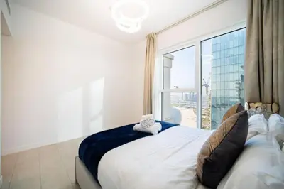 a bedroom with a large bed with a large window at LA VIE JBR, Sea & Palm View Apartment in Dubai