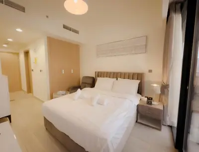 a bedroom with a large white bed in a room at Lavish Studio Pool Gym, Balcony, Netflix Fast Wi-Fi in Dubai