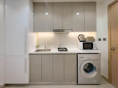 a kitchen with a washing machine and a microwave at Lavish Studio Pool Gym, Balcony, Netflix Fast Wi-Fi in Dubai