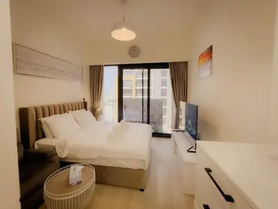 a hotel room with a bed and a television at Lavish Studio Pool Gym, Balcony, Netflix Fast Wi-Fi in Dubai