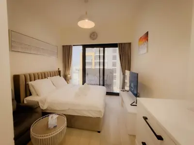a bedroom with a bed and a tv in a room at Lavish Studio Pool Gym, Balcony, Netflix Fast Wi-Fi in Dubai