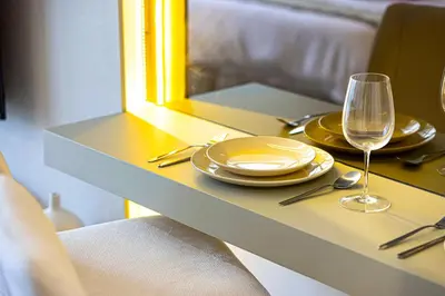 a table with a plate and a glass of wine at BRAND NEW Studio in Azizi Riviera in Dubai