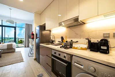 a kitchen with a sink and a stove top oven at BRAND NEW Studio in Azizi Riviera in Dubai