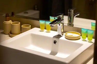 a bathroom sink with two glasses and a faucet at BRAND NEW Studio in Azizi Riviera in Dubai