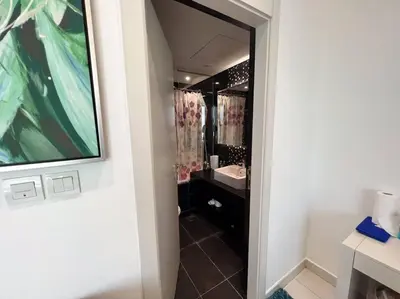 a bathroom with a walk in shower and a sink at In Vogue Live On the Canal in Business Bay in Dubai