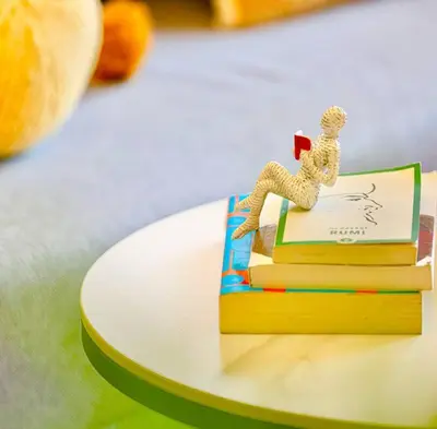 a figurine of a man sitting on top of books at Gorgeous 2BR with full Burj Khalifa view, 5 mins from Dubai Mall in Dubai