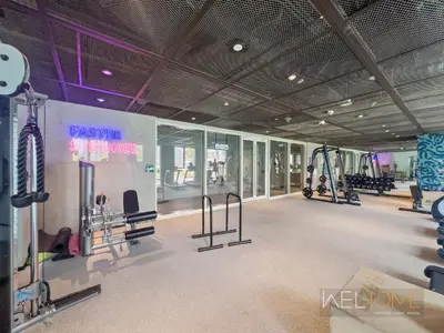 a gym with treadmills and machines in a building at WelHome - Beautiful 1BR Apt in Dubai Hills with City View in Dubai