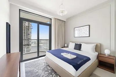 a bedroom with a large bed and a large window at Silkhaus Family Ideal & High Floor 2BDR in Dubai