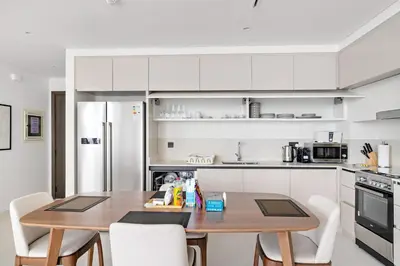 a kitchen with a wooden table and white cabinets at Silkhaus Family Ideal & High Floor 2BDR in Dubai