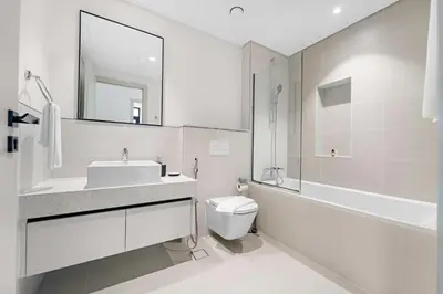 a white bathroom with a sink and a toilet at Silkhaus Family Ideal & High Floor 2BDR in Dubai