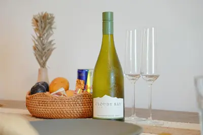 a bottle of wine and a basket of fruit and glasses at Luxury Downtown Dubai Burj Khalifa & Fountain View in Dubai