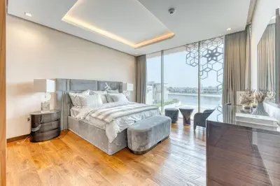 a bedroom with a large bed and a large window at World Class Luxurious 6 BDR Villa In Palm Jumeriah in Dubai