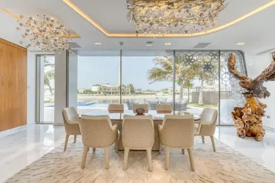 a dining room with a table and chairs and a chandelier at World Class Luxurious 6 BDR Villa In Palm Jumeriah in Dubai