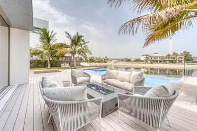 a patio with a table and chairs and a pool at World Class Luxurious 6 BDR Villa In Palm Jumeriah in Dubai
