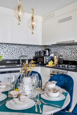 a kitchen with a table with plates and wine glasses at Frank Porter - Aykon City Tower in Dubai